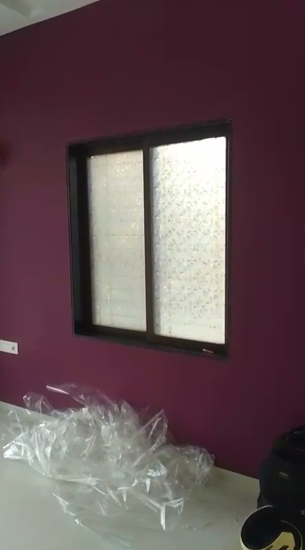 Video of a single sliding bedroom window finished in crystal-pattern privacy film, offcut sheeting on the table below