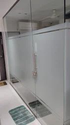 Frosted film on an office cabin's glass partition and matching double glass doors with a slim vertical handle