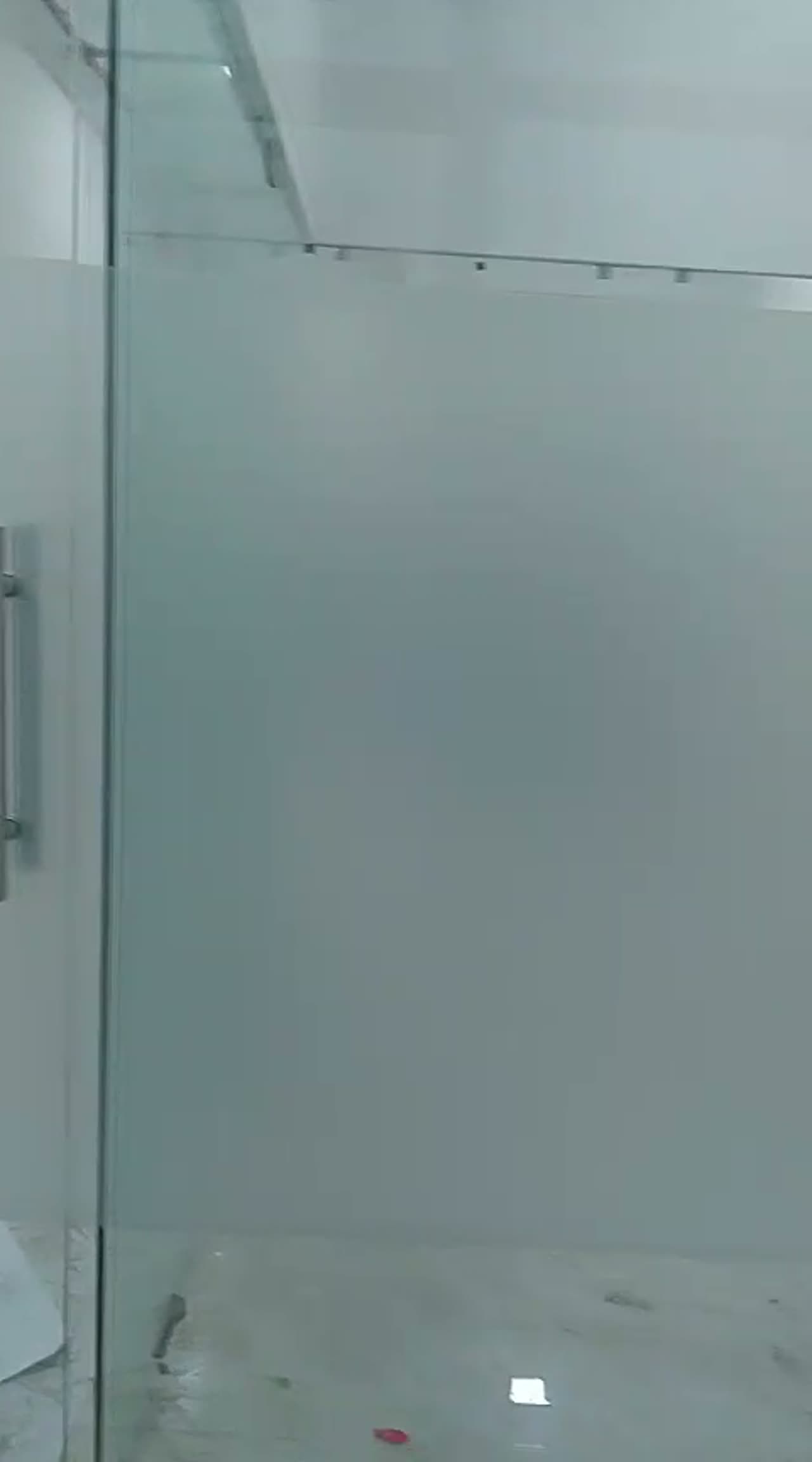 Video of a frosted glass partition and door in a newly built office cabin, floor still under finishing
