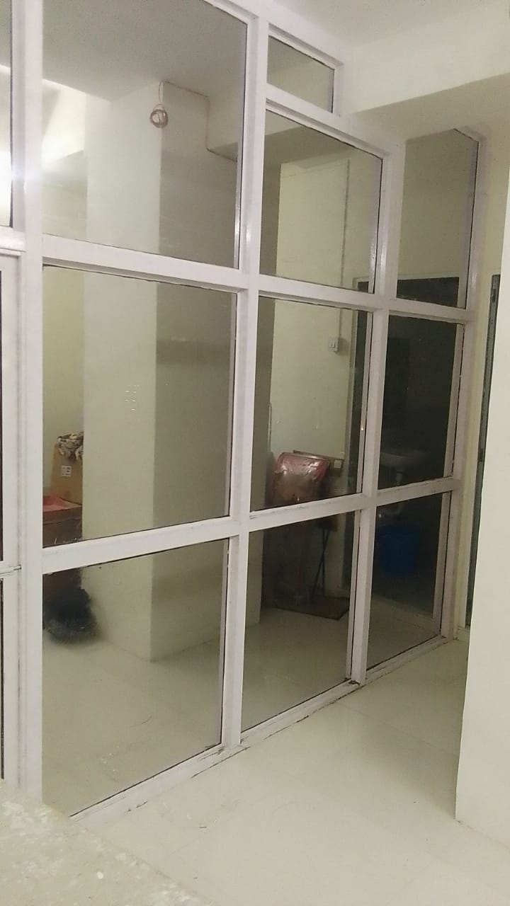 White-framed internal glass grid partition with untreated clear panes in an empty unit
