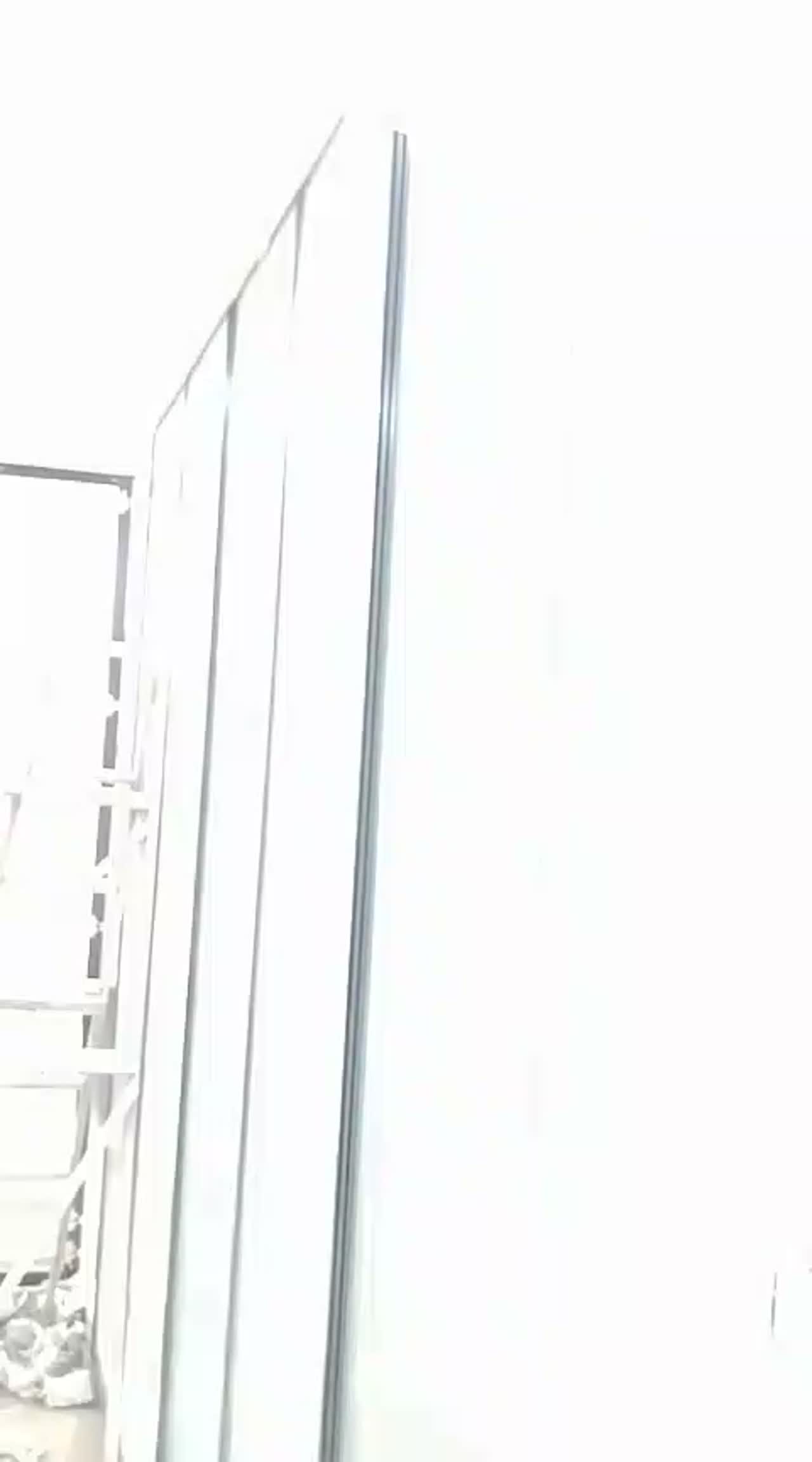 Reeded film partition panels mid-installation with discarded release liner covering the floor and a ladder in place