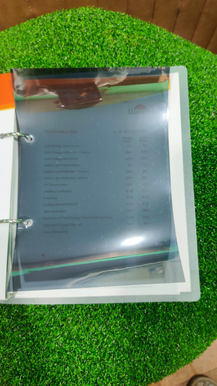 Film sample binder open to a performance data page listing solar energy, visible light and U-value figures