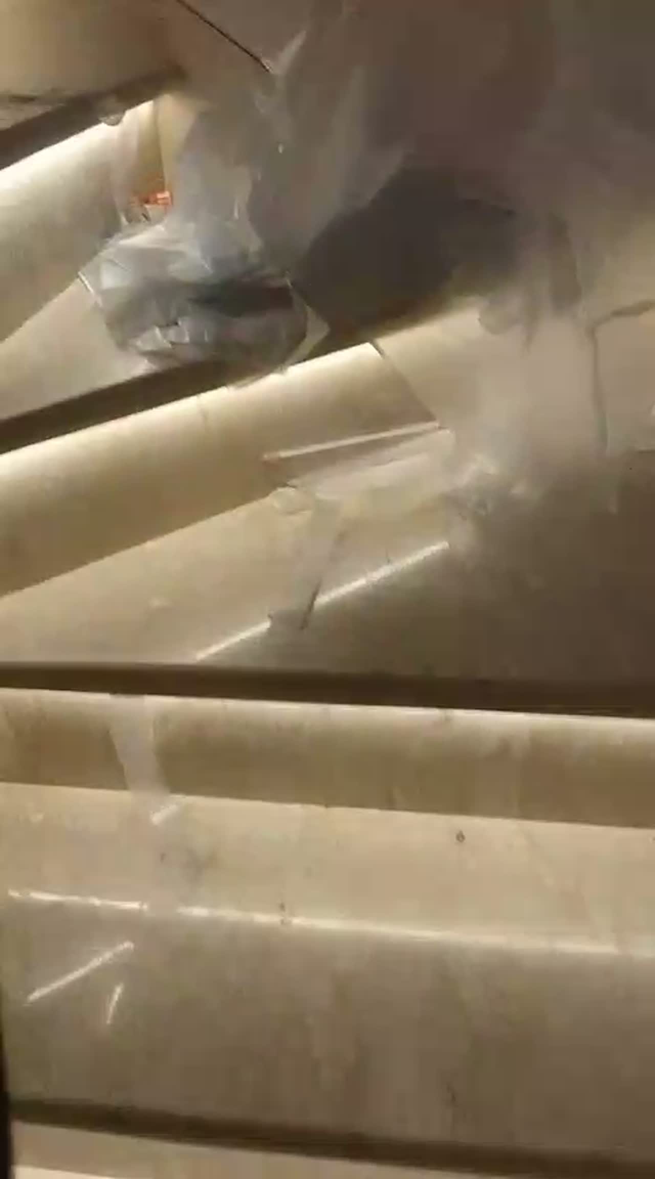 Video of a marble staircase covered in protective sheeting with a spray bottle and squeegee during balustrade film work